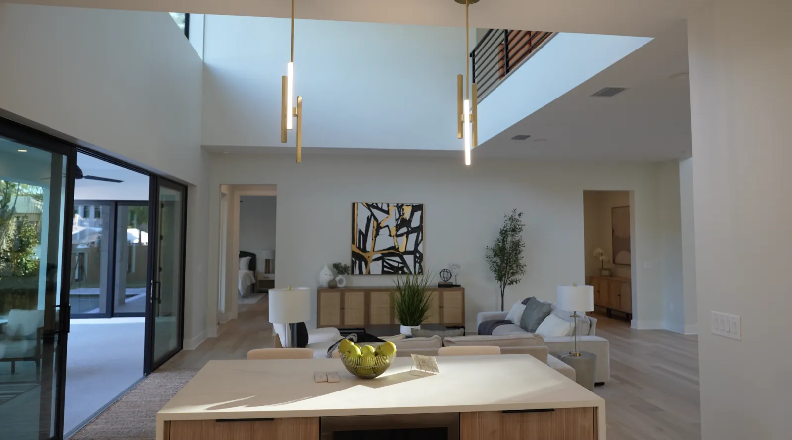 Kitchen island with pendant lighting overlooking a double-height living room